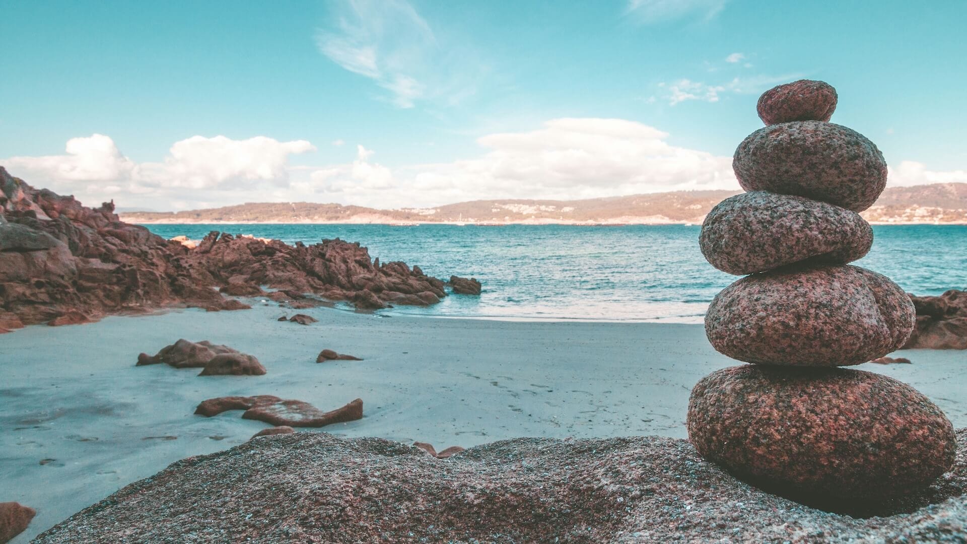 Sassi impilati sulla spiaggia, simbolo di meditazione e crescita personale